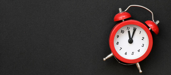 Red alarm clock on a black background