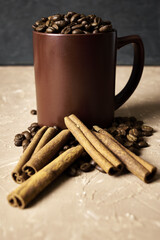 coffee beans with cinnamon and a coffee mug on the table with a copy space
