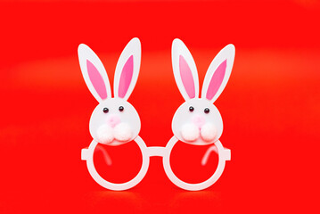 Two Toy Rabbit Bunny symbol of new year 2023 on red isolated background.Christmas or New Year concept.Copy space.
