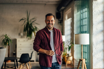 Photo of a smiling businessman, casually dressed, holding his gl © bnenin