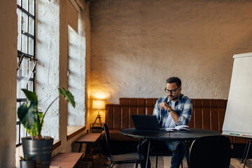 Serious-looking businessman having an online meeting, over the l