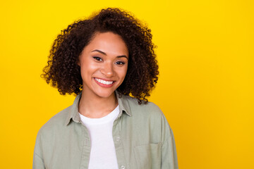Obraz na płótnie Canvas Photo of toothy curly millennial brunette lady wear grey shirt isolated on vivid yellow color background