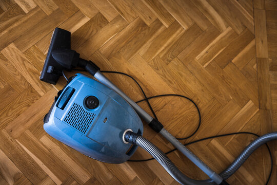 Old-fashioned vacuum cleaner on wooden floor