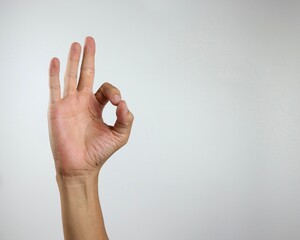 An Asian man's right hand making OK sign isolated over white background 