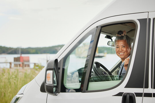 Portrait Of Smiling Senior Woman Sitting In Van