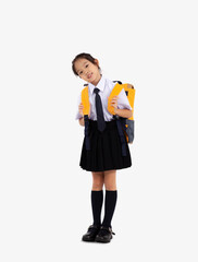 Asian student in school uniform with yellow backpack posing standing full length white background....