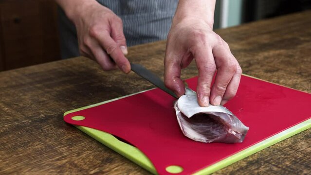 Close up shot of chef cutting out top fillet from Japanese horse mackerel