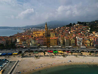 Aerial view of Menton in French Riviera from above. Drone view of France Cote d'Azur sand beach beneath the colorful old town of Menton. Small color houses near the border with Italy, Europe.