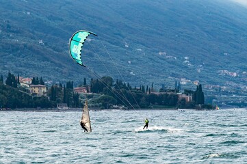  Surfer und Kitesurfer im Wind des Gardasees