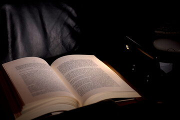 cell phone and power bank on the desk illuminates reading and study book, energy poverty concept...