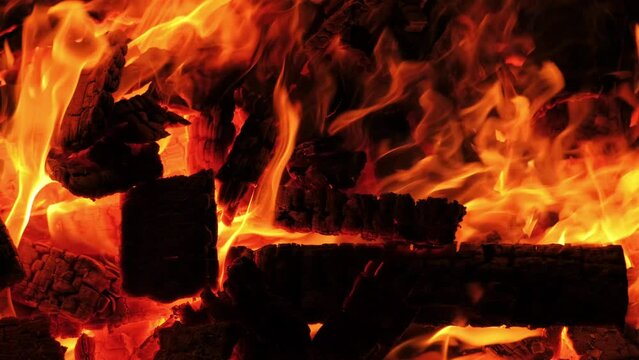 Close up footage of logs in flame during night fire camp.