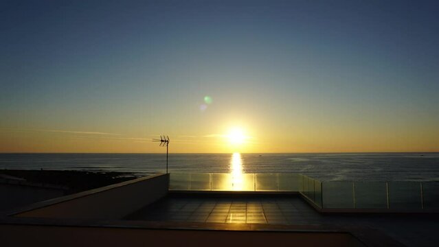 Time Lapse all'alba del sole che sorge dal mare tra le nuvole, vista da una terrazza fronte mare