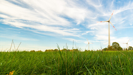 Low angle view of wind turbines on the field