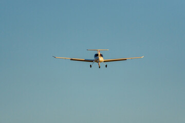 Frontal view of airplane approaching the runway at sunset