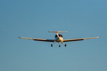 Frontal view of airplane approaching the runway at sunset