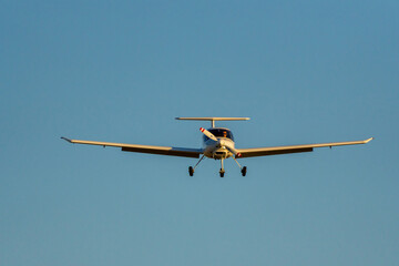 Frontal view of airplane approaching the runway at sunset