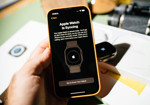 London, United Kingdom - Sep 23, 2022: new titanium Apple Watch Ultra is syncing message on iPhone 14 Pro during unboxing of most awaited Apple Computers device