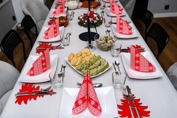 A table set before dinner for Christmas in Poland, visible spinach roulade with salmon and herring...