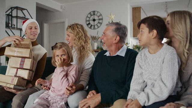 Big caucasian family receiving Christmas gifts from young uncle. Shot with RED helium camera in 8K.   