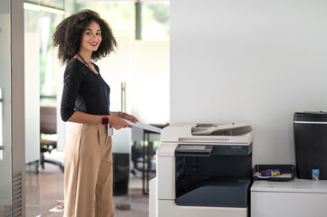 Woman in balck shirt and beige pants in the office looking determined