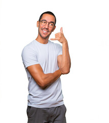 Amazed young man making a gesture of calling with the hand