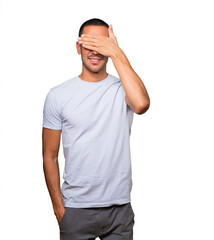 Fototapeta premium Young man covering his eyes with his hands