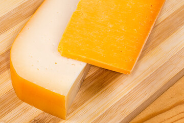 Different semi-hard cheese on a cutting board, close-up