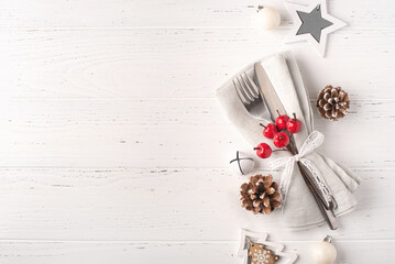 Christmas place setting on white wooden table. Copy space for text.
