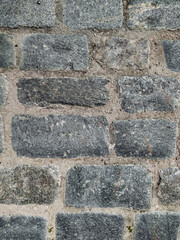 Texture of dark gray granite paving stones, top view. Background from natural block stone.