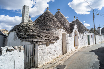 narrow cobblestone streets and round stone trulli houses in Arbelobello. Stone pointed roofs and...