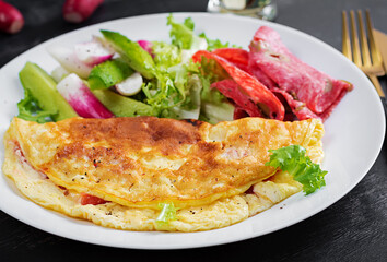Breakfast. Omelette with cheese and  fresh salad, salami. Frittata - italian omelet. Ketogenic lunch.