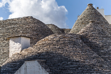 Fototapeta na wymiar narrow cobblestone streets and round stone trulli houses in Arbelobello. Stone pointed roofs and brick stone whitewashed houses on a sunny day