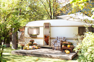 Wooden RV house porch with garden furniture. Campsite in garden. Wooden armchair near outside...