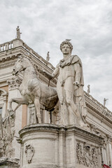 Statue of Apollo, Roman man with horse, Rome, Italy at dramatic rainy sky in city historical downtown.