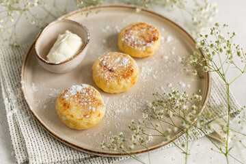 Ceramic plate with cottage cheese dessert and sauce