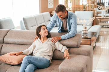 Obraz premium Front view. Couple choosing the sofa and bed in the store