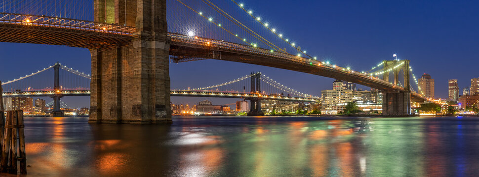 Evening panoramic view of the Brooklyn Bridge and Manhattan Bridge with East River. Dumbo, New York City