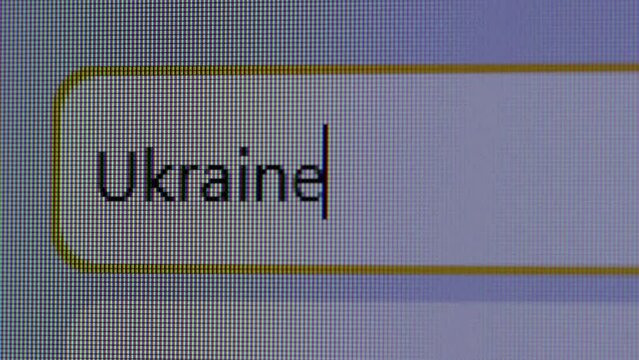 User enters text query for word Ukraine in search bar form of internet browser on computer. Macro pixels of monitor screen display. Political news. User presses Enter key on keyboard