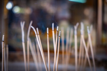 Joss stick with smoke and bokeh in the background