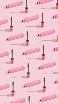 Creative vertical crop pattern with mascara brush on sunny pink background. Cosmetic studio concept