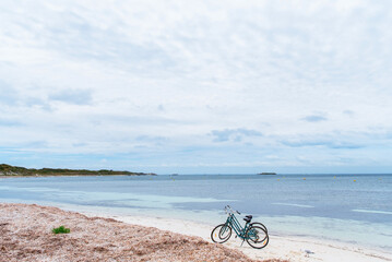 Obraz premium Two bicycles parked on a beach on Rottnest Island, Western Australia. Bike rental for tourists. Scenic view