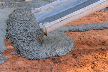 During process paving driveway, contractors from concrete construction industry are pouring wet concrete