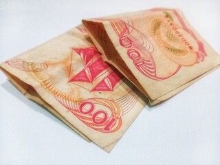 2 pieces of Indonesian currency (100 rupiah) on a white background