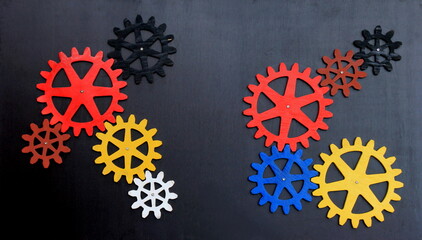 Colorful wooden gears on a black background. Space for text. A toy for children's development