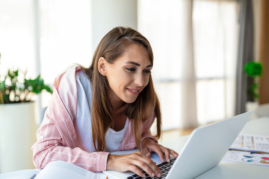 Young Woman Working Laptop. Business Woman Busy Working On Laptop Computer At Office. Businesswoman Sitting At Bright Modern Work Station And Typing On Laptop