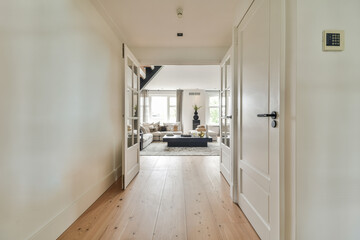 Light narrow hallway with many doors in white walls and glowing lamp over lumber floor