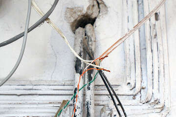 Hazard electrical wiring. Exposed wire in the electrical wiring in the wall. Selective focus