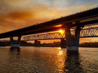 Two bridges over the sunset river. Railway and Fourth automobile Central bridge under construction across the Ob River. Novosibirsk