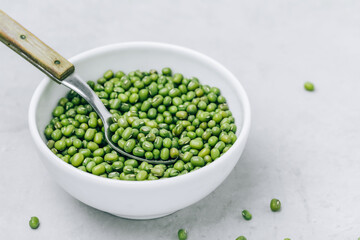 Green Gram. Organic Mung Beans in bowl on gray stone background.