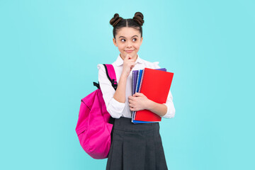 School girl hold copybook and book on yellow blue isolated studio background. School and education concept. Teenager girl in school uniform. Happy teenager, positive and smiling emotions of teen girl.